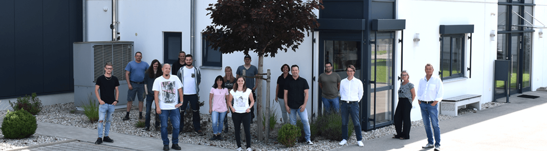 Gruppenbild Jubiläum von rolf weigel Mitarbeitern vor dem Gebäude