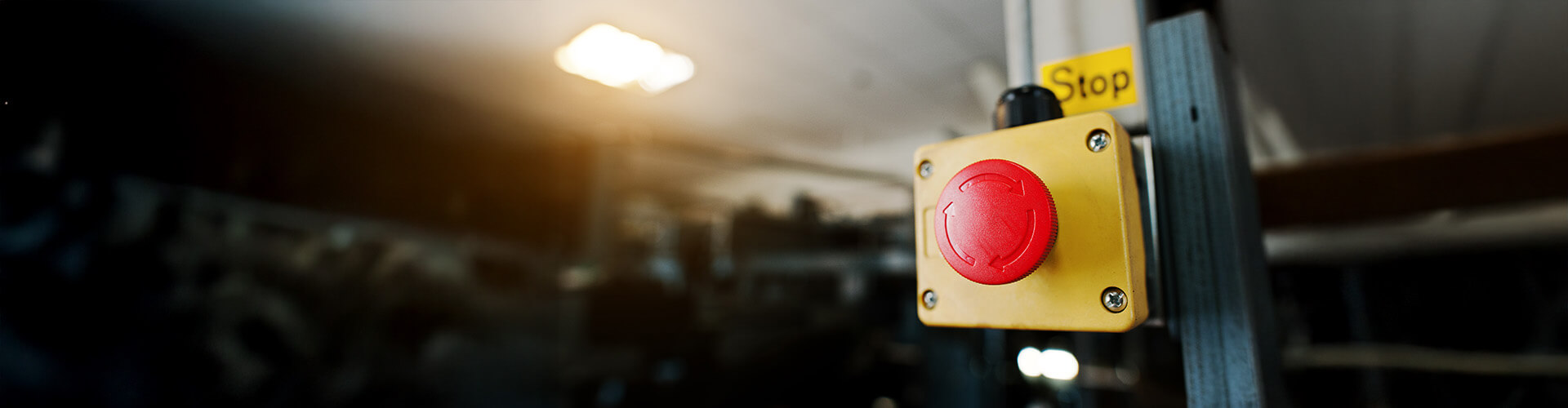 Ein rotgelber Not-Aus-Schalter an einer Säule befestigt
