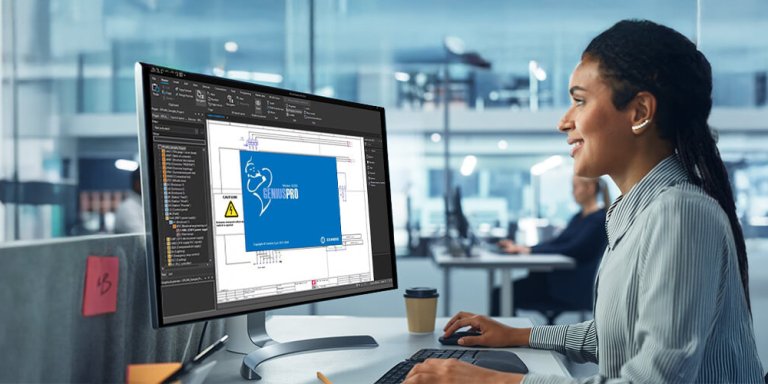 Eine Frau arbeitet in einem Großraumbüro an einem PC. Auf dem Bildschirm sieht man den Cembre EPlan.
