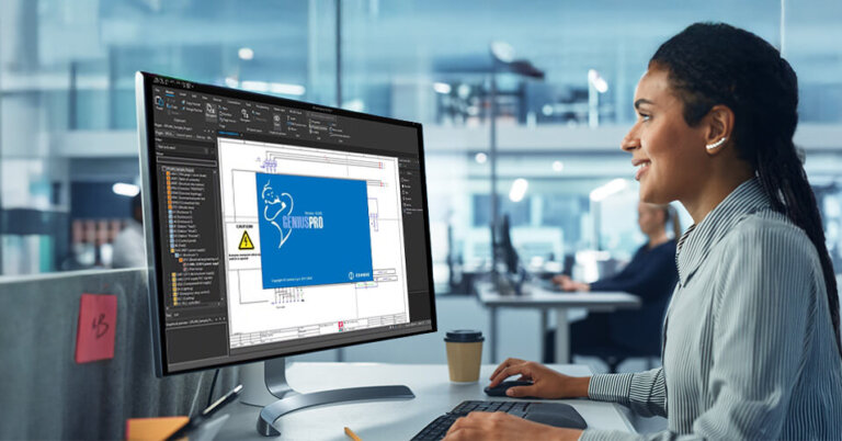 Eine Frau arbeitet in einem Großraumbüro an einem PC. Auf dem Bildschirm sieht man den Cembre EPlan.