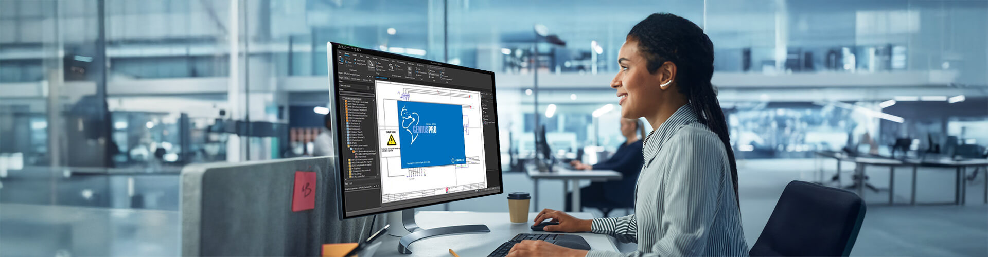 Eine Frau arbeitet in einem Großraumbüro an einem PC. Auf dem Bildschirm sieht man den Cembre EPlan.