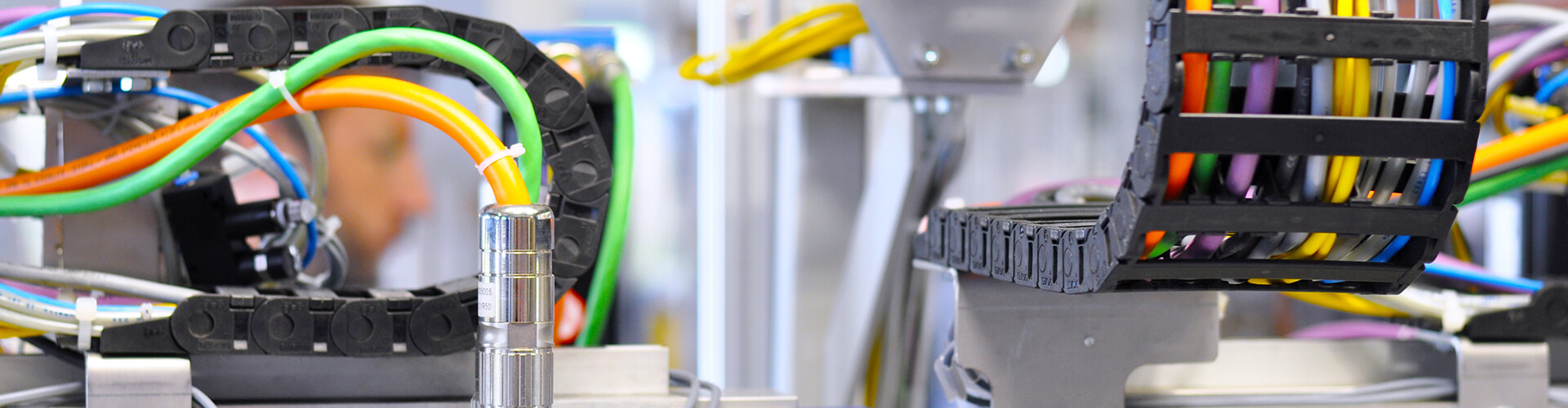 Diverse Kabel die mithilfe von Schleppketten verlegt wurden und an den durch Kabelkonfektion Stecker angebracht sind.