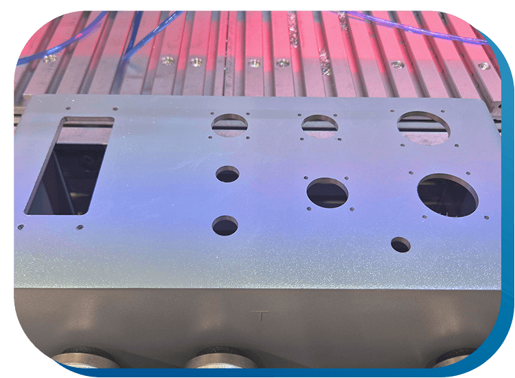 Ein Aluminium-Gehäuse, das in einer CNC-Maschine zur Gehäusebearbeitung eingespannt wurde. In dem diverse Bohrungen und Ausschnitte gefräst wurden.