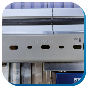 Ein Verdrahtungskanal, der in einer CNC-Maschine eingespannt ist. Mithilfe der Maschine wurden die Zahlen 411.81.0072 auf der Unterseite des Kanals graviert.