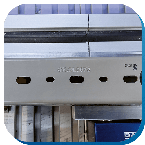 Ein Verdrahtungskanal, der in einer CNC-Maschine eingespannt ist. Mithilfe der Maschine wurden die Zahlen 411.81.0072 auf der Unterseite des Kanals graviert.