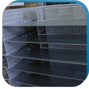 Verdrahtungskanäle und Hutschienen, die auf Montageplatten vormontiert wurden, als vorbereitenden Schritt in der Gehäusebearbeitung.