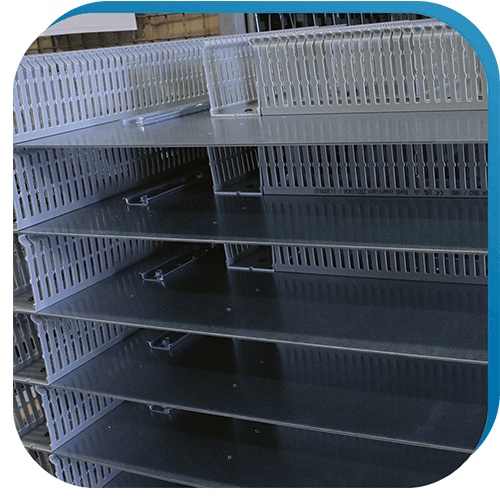 Verdrahtungskanäle und Hutschienen, die auf Montageplatten vormontiert wurden, als vorbereitenden Schritt in der Gehäusebearbeitung.