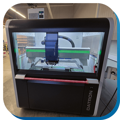 Die CNC-Fräse DATRON M8Cube in der Komplettansicht im Maschinenpark von rolf weigel. Sie fräst Löcher in ein Alu-Gehäuse.