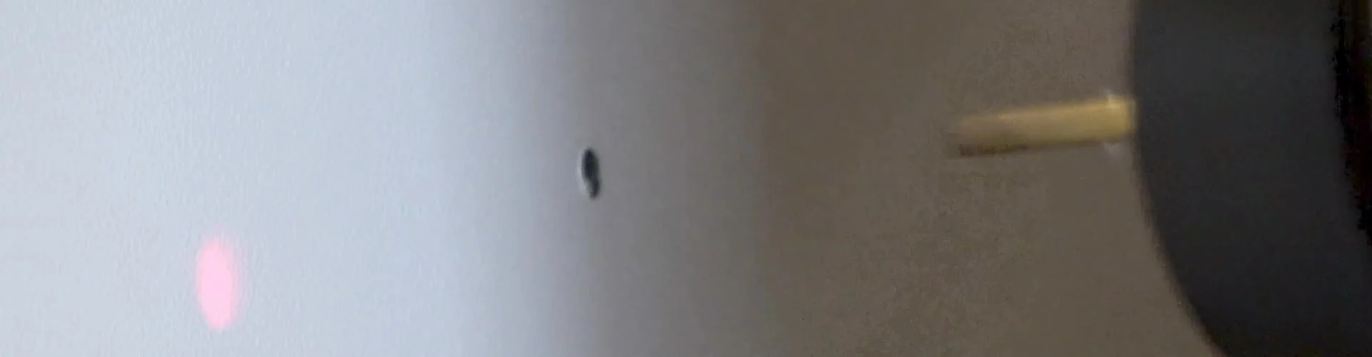 Ein Bohraufsatz einer CNC-Maschine der sich zur Bearbeitung einer Schaltschranktür nähert.