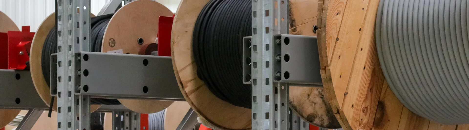 Große Kabelrollen in Aufhängungen im Lager